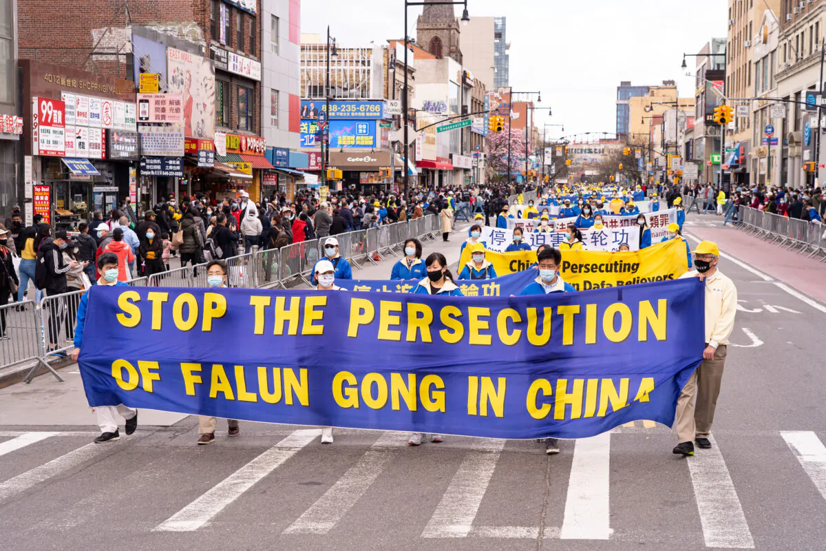 Falun Gong practitioners take part in a parade in Flushing, New York, on April 18, 2021, to commemorate the 22nd anniversary of the April 25th peaceful appeal of 10,000 Falun Gong practitioners in Beijing. (Larry Dye/The Epoch Times)