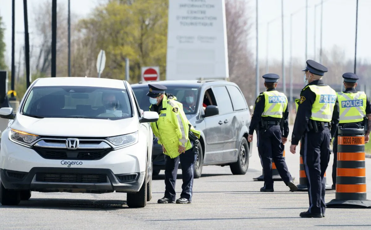 Motorists are screened at a police checkpoint to limit non-essential travel from Quebec to Ontario on Highway 401 near Bainsville, Ont., on April 19, 2021. (The Canadian Press/Paul Chiasson)