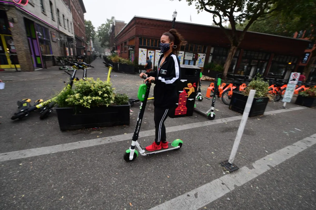 A woman wears a mask as she rides a scooter in downtown Portland, Ore., on Sept. 14, 2020. (Robyn Beck/AFP via Getty Images)