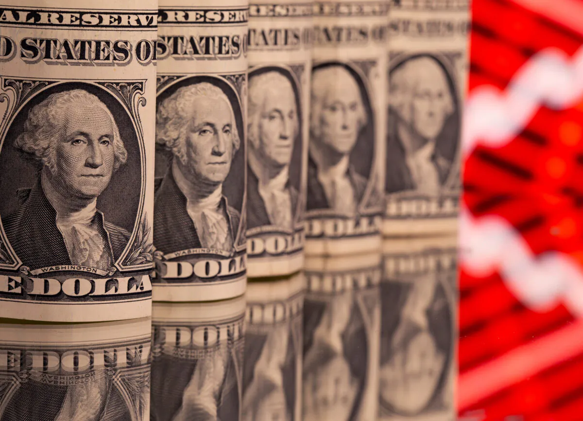 U.S. one dollar banknotes are seen in front of displayed stock graph in this illustration on Feb. 8, 2021. (Dado Ruvic/Illustration/File Photo/Reuters)