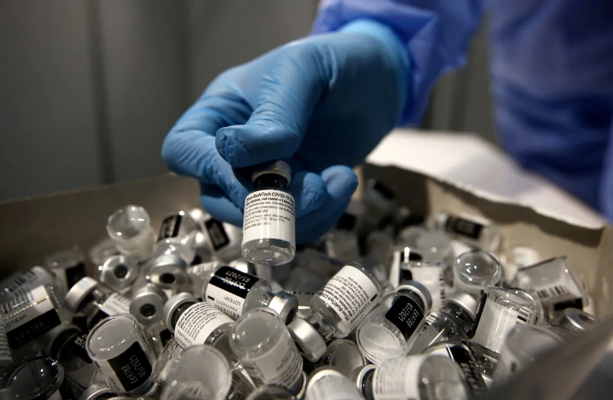 A nurse puts a used Pfizer-BioNTech COVID-19 vaccine vial in a disposal box with empty vials at Messe Wien Congress Center, which has been set up as a COVID-19 vaccination center, in Vienna, Austria, on Feb. 7, 2021. (Lisi Niesner/Reuters)