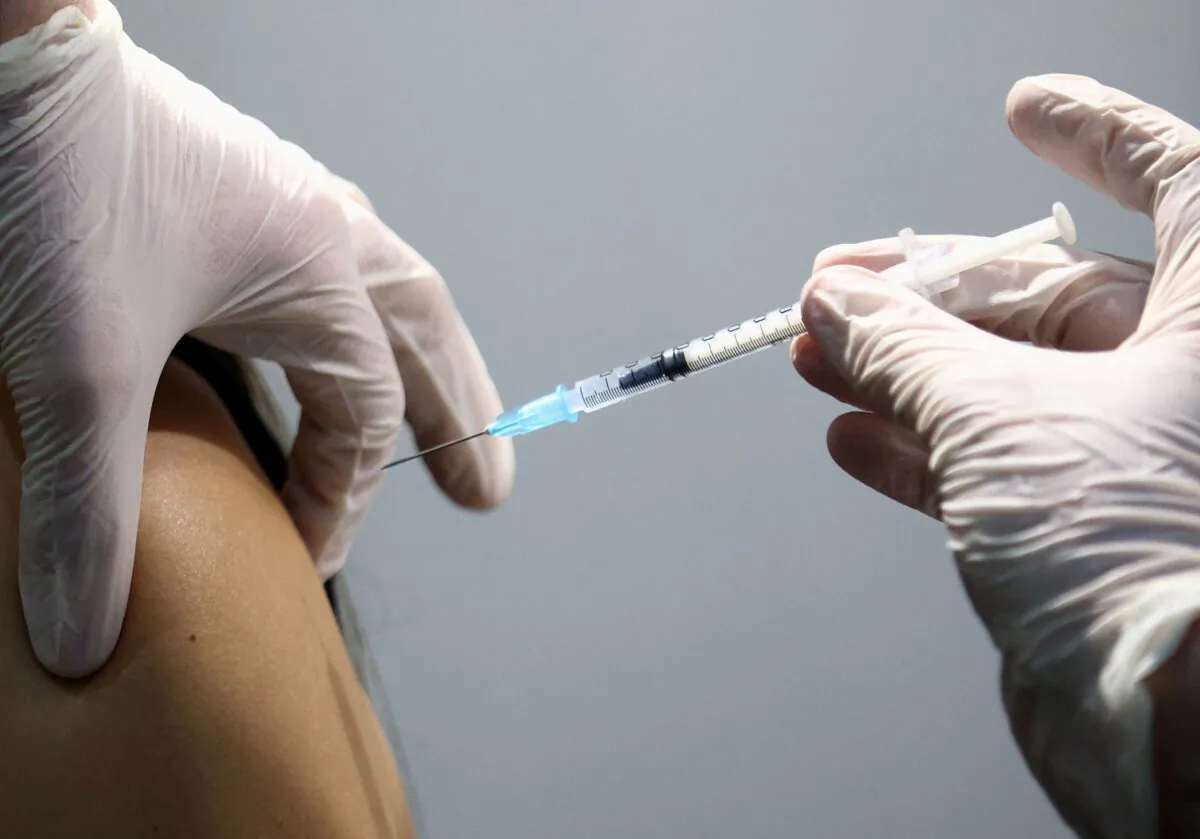 A healthcare worker receives a dose of a Pfizer-BioNTech COVID-19 vaccine at Messe Wien Congress Center, which has been set up as a coronavirus disease vaccination centre, in Vienna, Austria, on Feb. 7, 2021. (Lisi Niesner/Reuters)