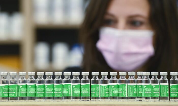 Pharmacist Barbara Violo arranges all the empty vials of the Oxford-AstraZeneca COVID-19 vaccines that she has provided to customers at the Junction Chemist which is a independent pharmacy during the COVID-19 pandemic in Toronto, on April 19, 2021. (THE CANADIAN PRESS/Nathan Denette)