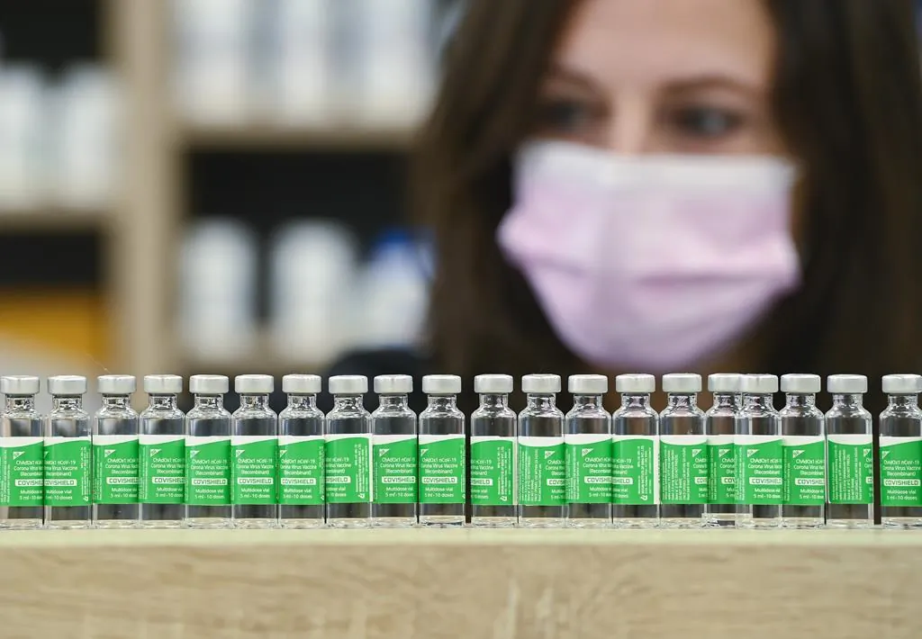 Pharmacist arranges all the empty vials of the Oxford-AstraZeneca COVID-19 vaccines in Toronto, Canada, on April 19, 2021. (The Canadian Press/Nathan Denette)