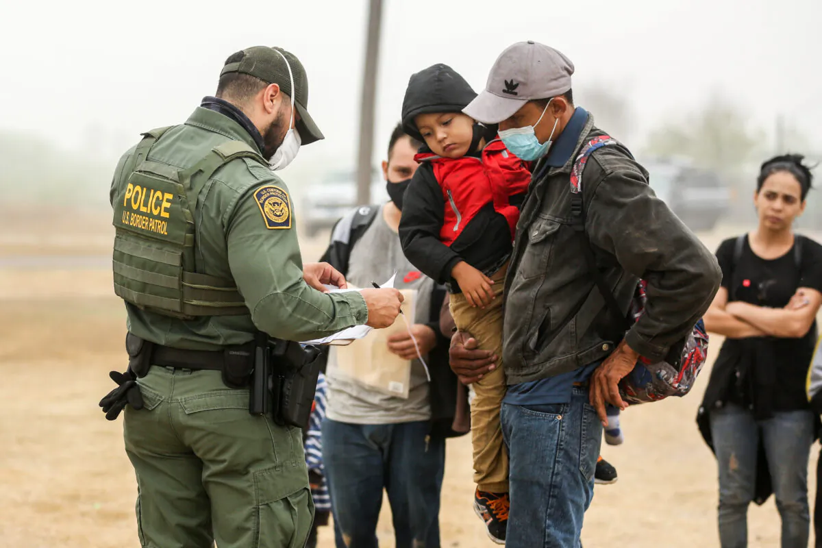 A group of illegal immigrants with Border Patrol after crossing the U.S.-Mexico border in La Joya, Texas, on April 10, 2021. (Charlotte Cuthbertson/The Epoch Times)