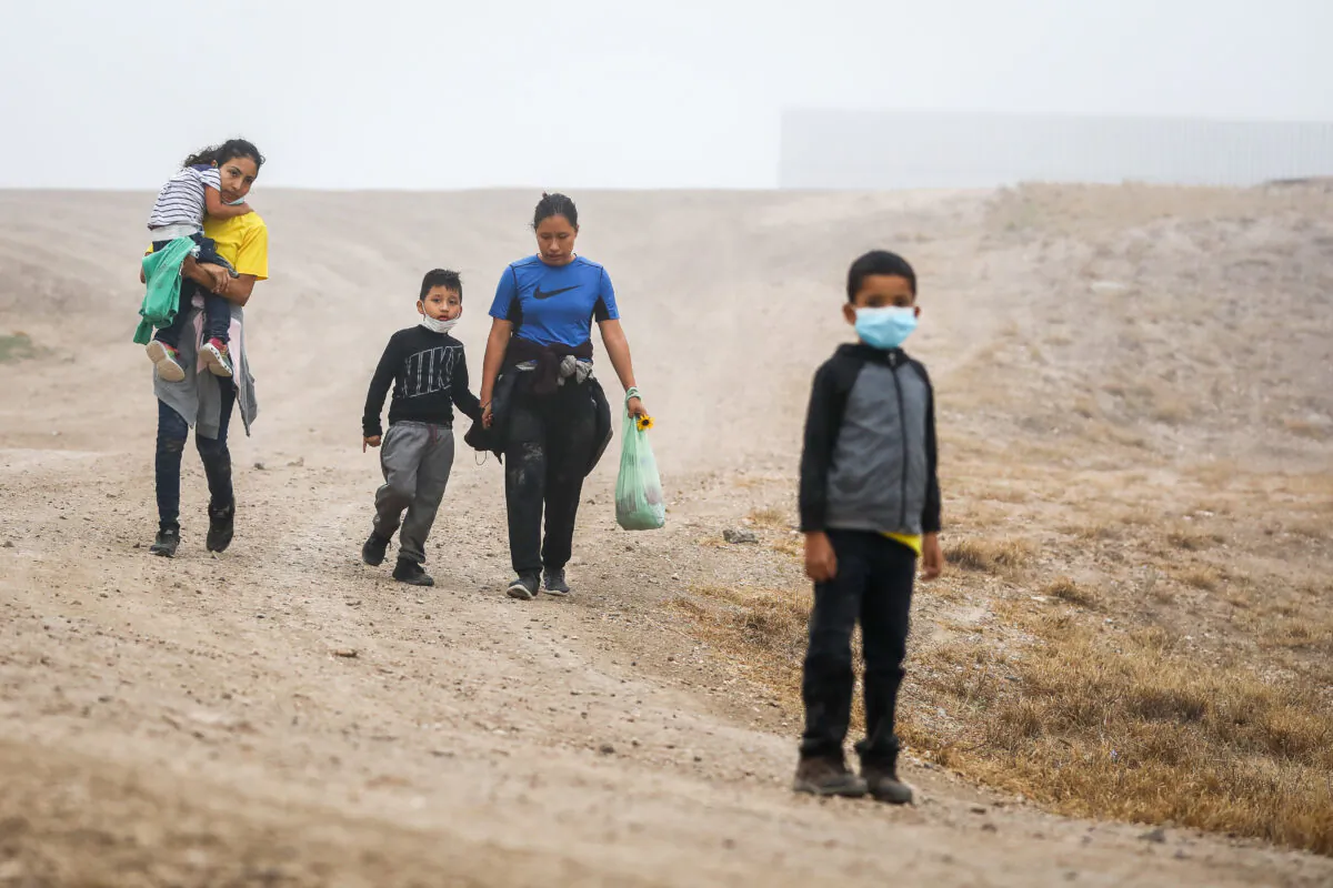 A group of illegal immigrants walk towards Border Patrol after crossing the U.S.-Mexico border in La Joya, Texas, on April 10, 2021. (Charlotte Cuthbertson/The Epoch Times)