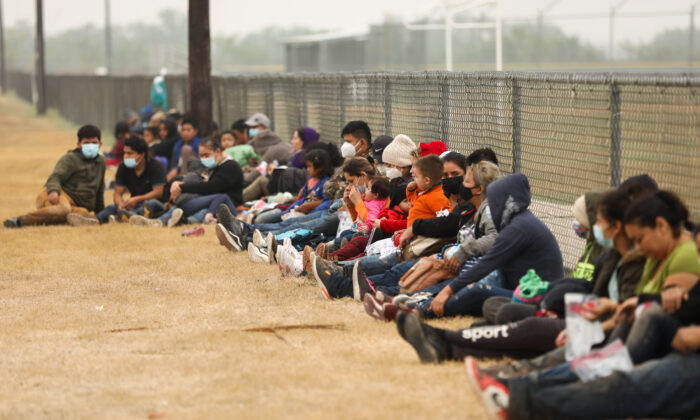 A group of illegal immigrants wait for Border Patrol after crossing the U.S.-Mexico border in La Joya, Texas, on April 10, 2021. (Charlotte Cuthbertson/The Epoch Times)