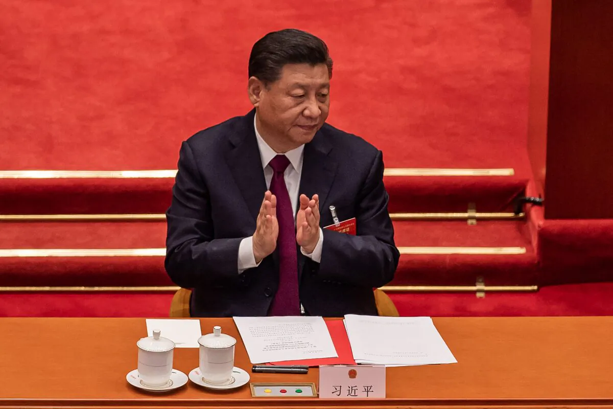 Chinese leader Xi Jinping applauds at the Great Hall of the People in Beijing on March 11, 2021. (Nicolas Asfouri/AFP via Getty Images)