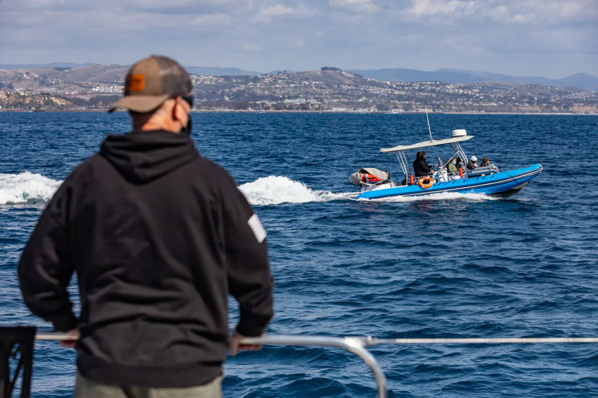 Passengers look on during a whale watching excursion in Dana Point, Calif., on March 8, 2021. (John Fredricks/The Epoch Times)