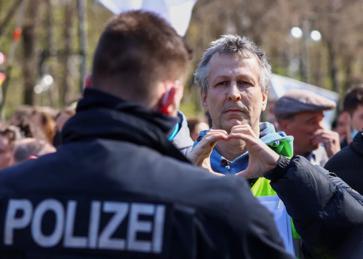 A man gestures to the police as he takes part in a protest against the government measures to curb the spread of the coronavirus disease (COVID-19), as the lower house of parliament Bundestag discusses additions for the Infection Protection Act, in Berlin, Germany, on April 21, 2021. (Christian Mang/Reuters)