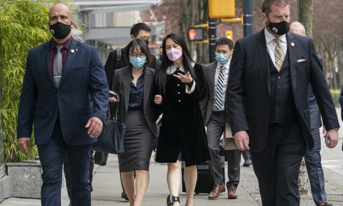 Meng Wanzhou, chief financial officer of Huawei, walks down the street with an acquaintance after leaving B.C. Supreme Court during a lunch break at her extradition hearing, in Vancouver, B.C., on April 1, 2021. (THE CANADIAN PRESS/Rich Lam)