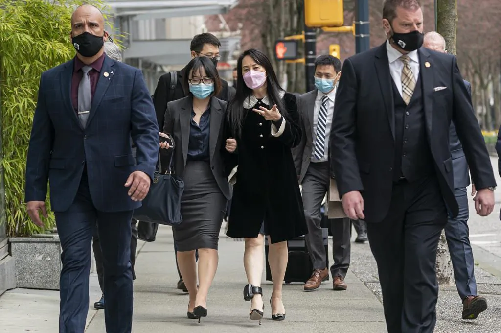 Meng Wanzhou, chief financial officer of Huawei, walks down the street with an acquaintance after leaving B.C. Supreme Court during a lunch break at her extradition hearing, in Vancouver, B.C., on April 1, 2021. (THE CANADIAN PRESS/Rich Lam)
