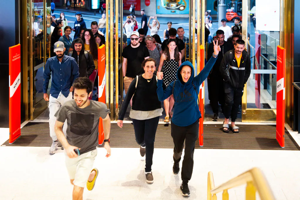 Customers run through the doors of the David Jones Elizabeth Street store for the 6 a.m. opening during the Boxing Day sales on Dec. 26, 2019, in Sydney, Australia. (Jenny Evans/Getty Images)