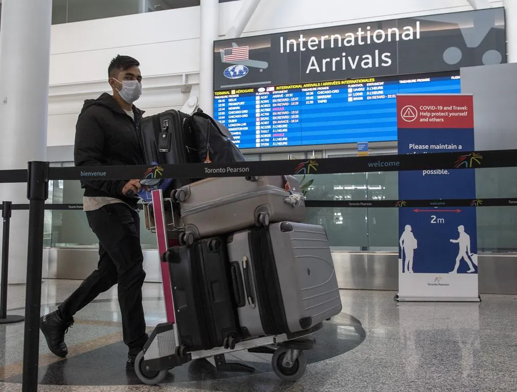 A passenger from Air India flight 187 from New Delhi arrives at Pearson Airport in Toronto on April 21, 2021. (The Canadian Press/Frank Gunn)