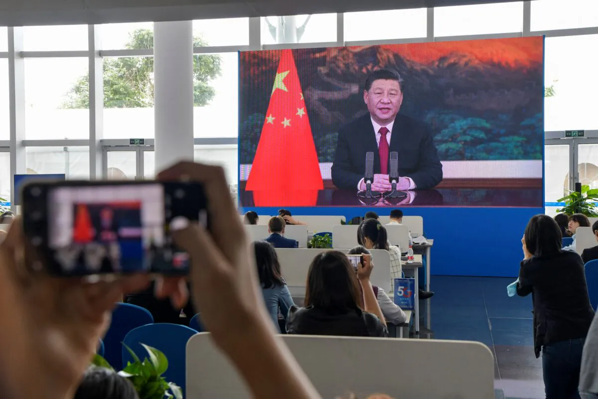 Journalists watch a screen showing China's Leader Xi Jinping delivering a speech during the opening of the Boao Forum for Asia (BFA) Annual Conference 2021 in Boao, Hainan province, China, on April 20, 2021. (STR/AFP via Getty Images)