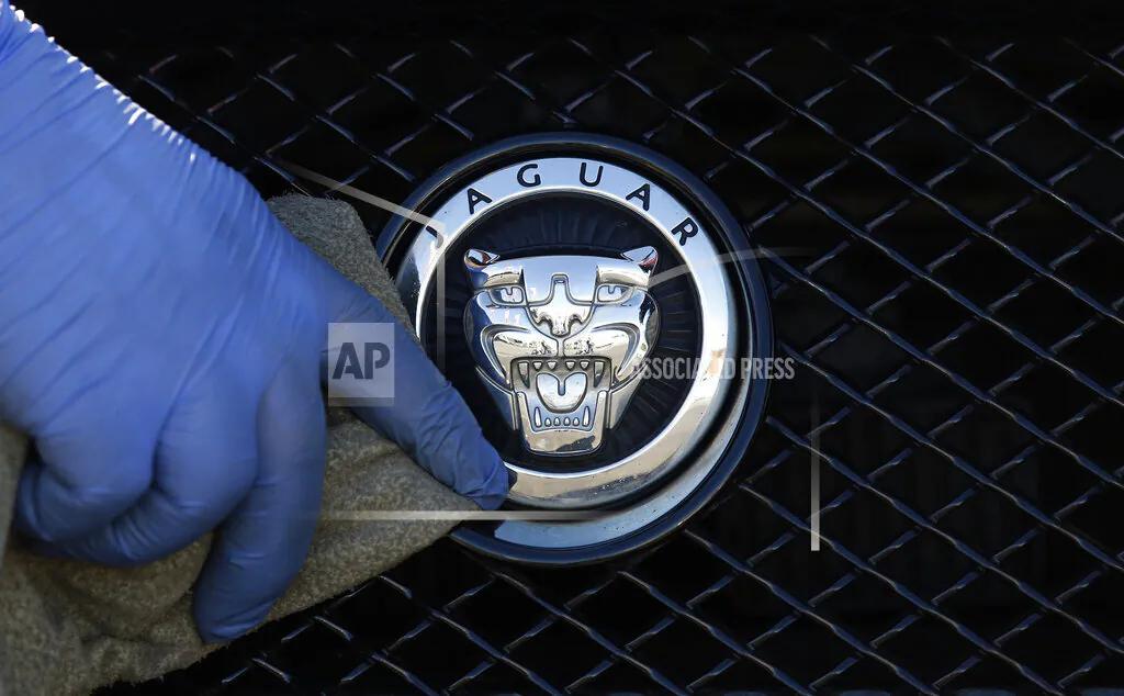 A worker polishes a Jaguar logo on a car at a Jaguar dealer in London, UK, on Wednesday Sept. 28, 2016. (Frank Austin/AP Photo file)