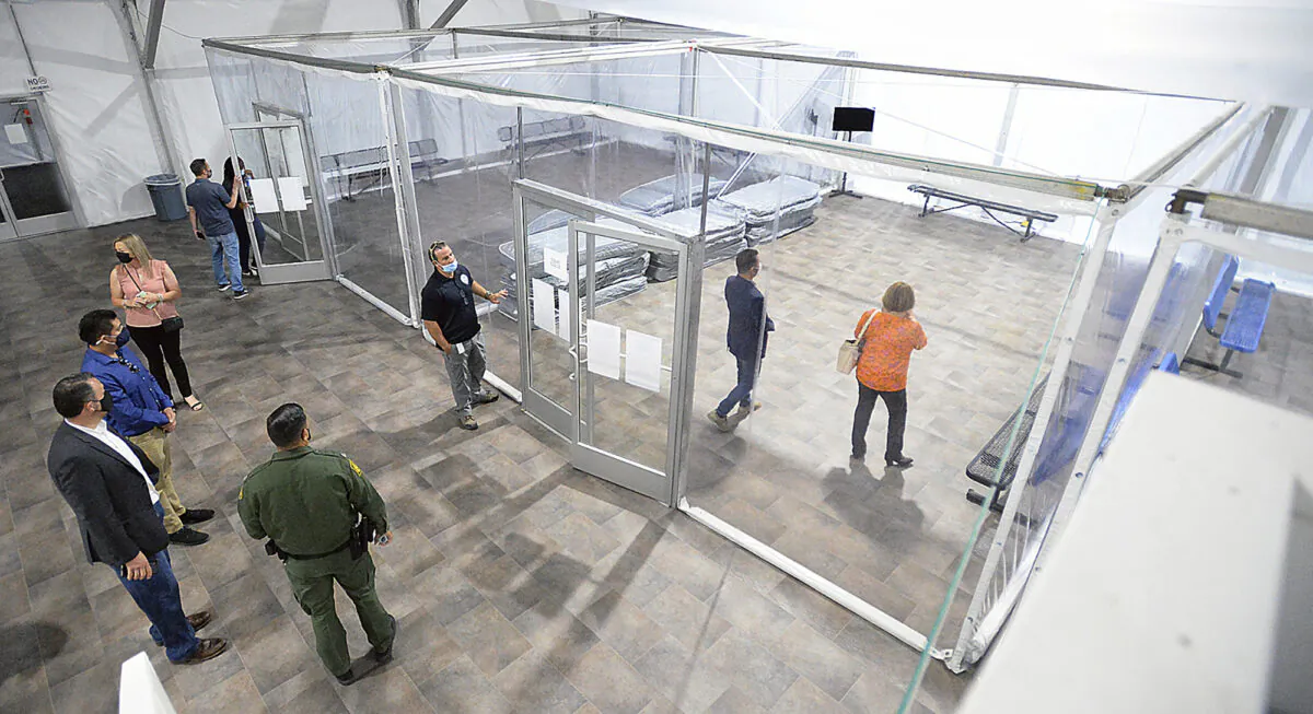 People touring the U.S. Border Patrol Yuma Sector, soft-sided processing facility, look at the pods inside one of four living areas at the facility, in Yuma, Ariz., on April 20, 2021. (Randy Hoeft/The Yuma Sun via AP)