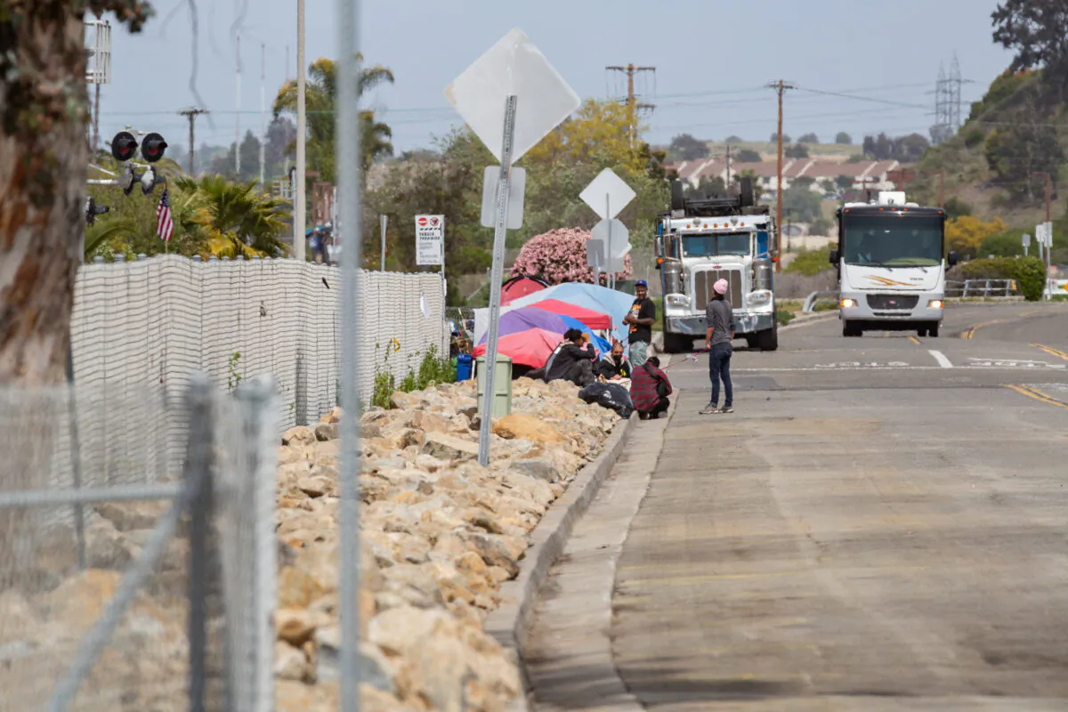 Homeless people gather near a tent in Oceanside, Calif., on April 14, 2021. (John Fredricks/The Epoch Times)