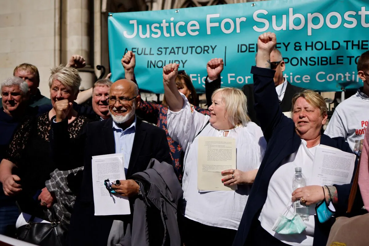 Former subpostmasters celebrate outside the Royal Courts of Justice in London, on April 23, 2021. (Tolga Akmen/AFP via Getty Images)