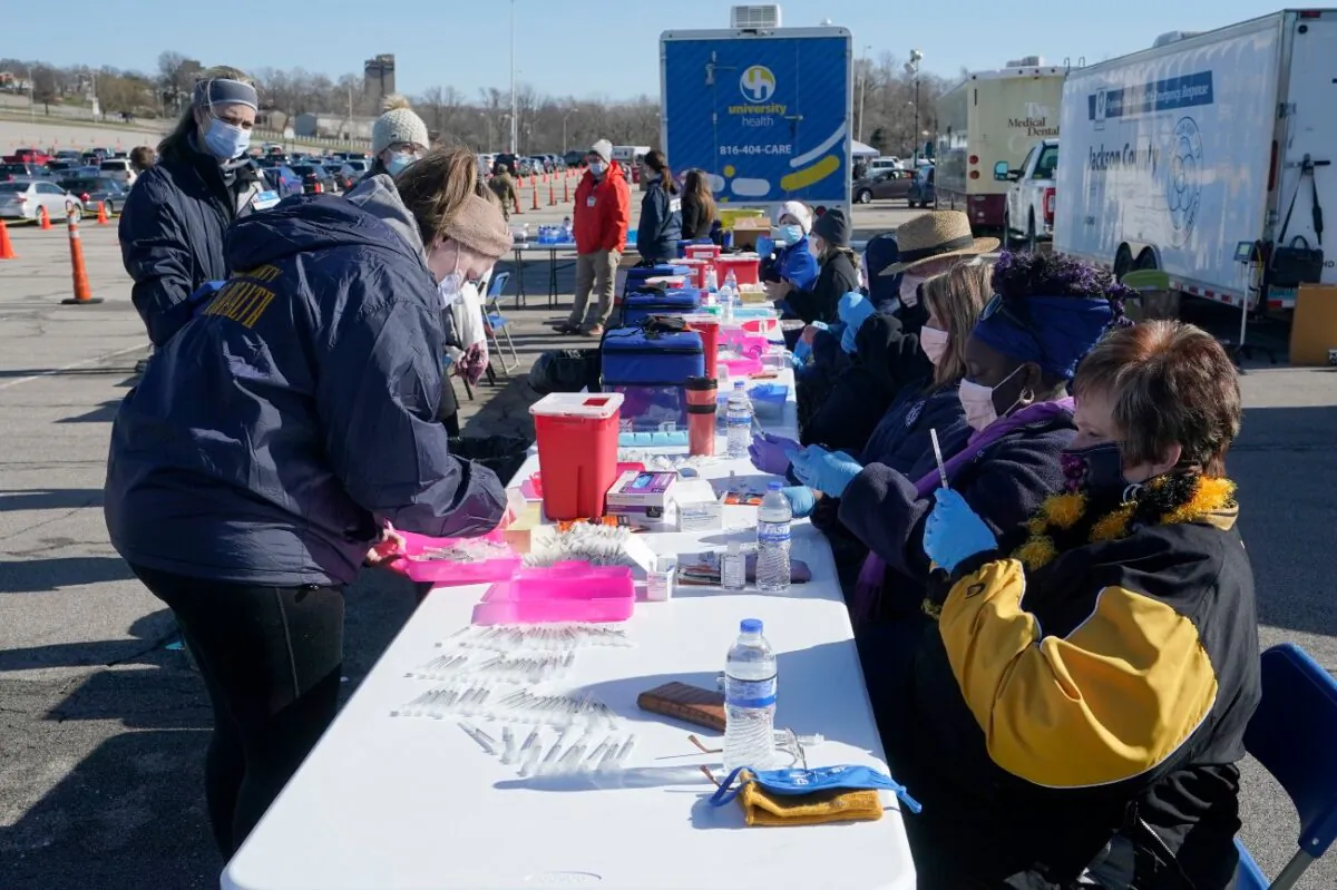 Nurses fill syringes with a COVID-19 vaccine at a mass vaccination site in Kansas City, Miss., on March 19, 2021. (Orlin Wagner/File/AP Photo)