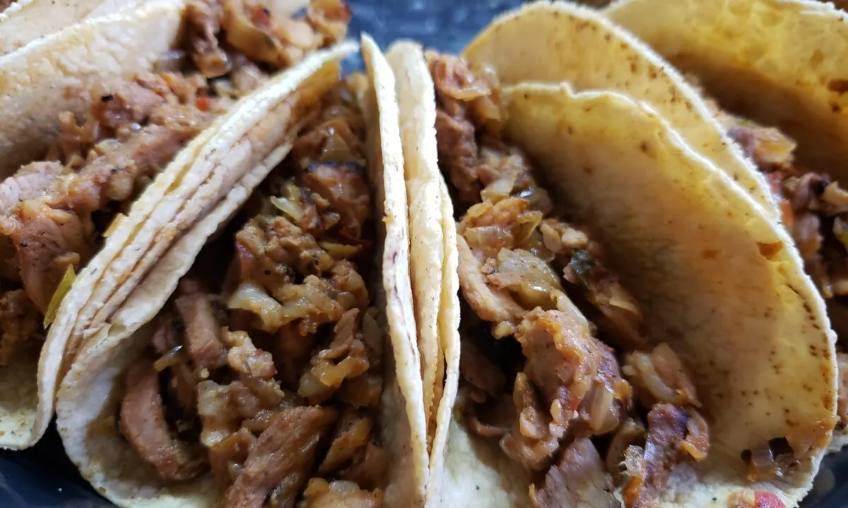 Celebrate Cinco de Mayo with these citrus-marinated pork tacos, served with side dishes of guacamole, sour cream, and salsa. (Dreamstime/TNS)