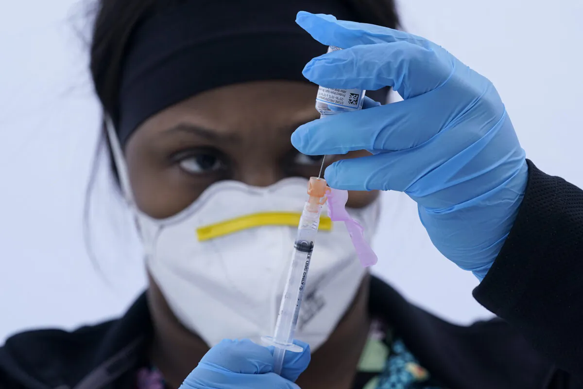 Licensed vocational nurse Jelisa Stewart prepares a dose of the Moderna COVID-19 vaccine for farmworkers at a County of Santa Clara mobile vaccination clinic at Monterey Mushrooms in Morgan Hill, Calif., on March 3, 2021. (Jeff Chiu/AP Photo)