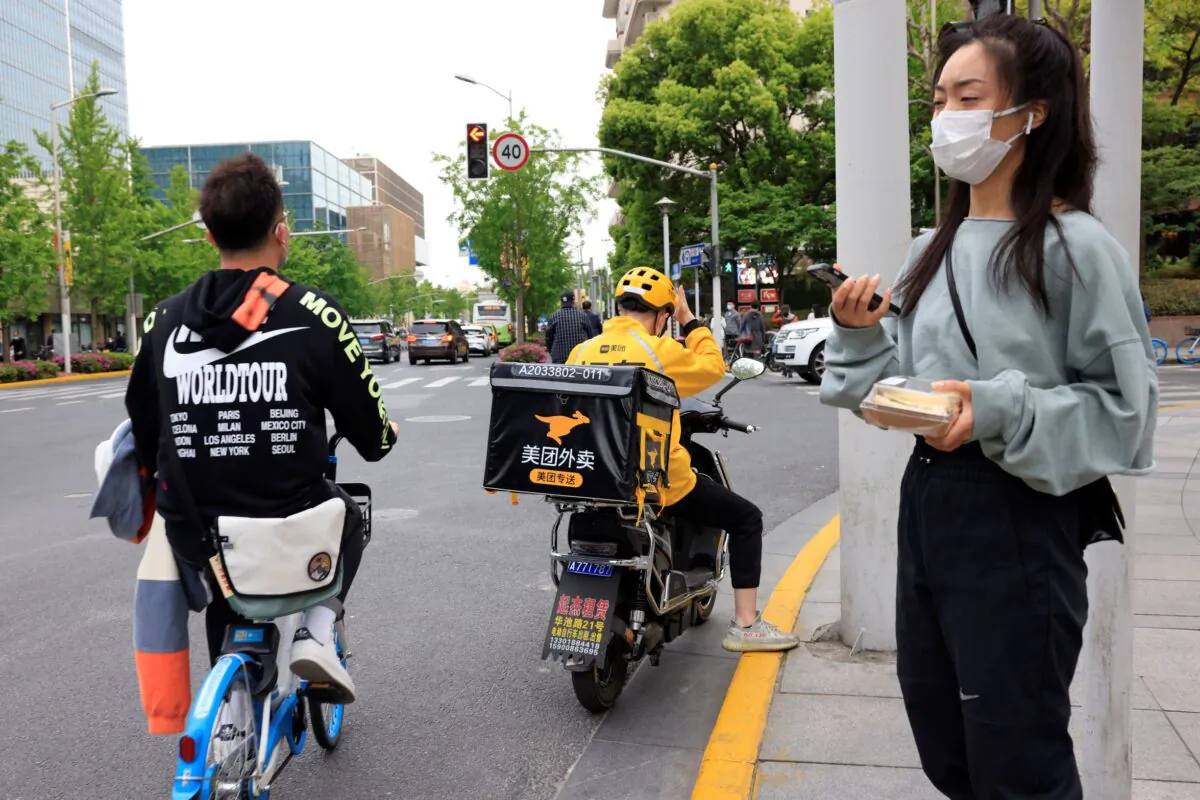 A Meituan delivery man in yellow goes on his rounds in Shanghai, China, on April 21, 2021. (Ng Han Guan/AP Photo)