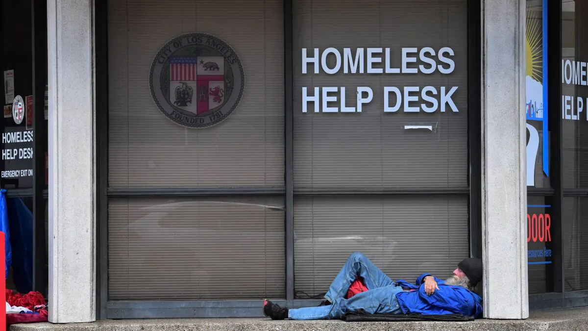 A man sleeps outside the Homeless Help Desk kiosk in the Skid Row community of Los Angeles, Calif., on April 26, 2021. (Frederic J. Brown/AFP via Getty Images)