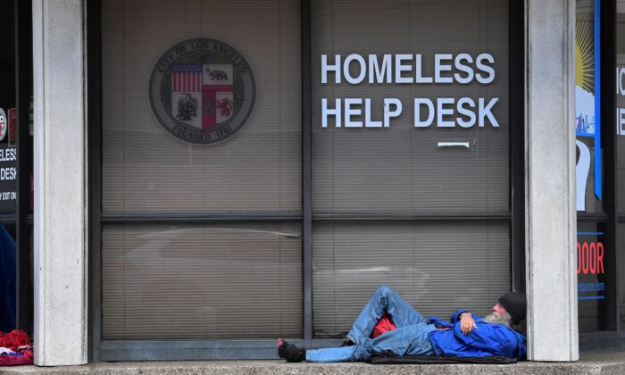 A man sleeps outside the Homeless Help Desk kiosk in the Skid Row community of Los Angeles on April 26, 2021. (Frederic J. Brown/AFP via Getty Images)