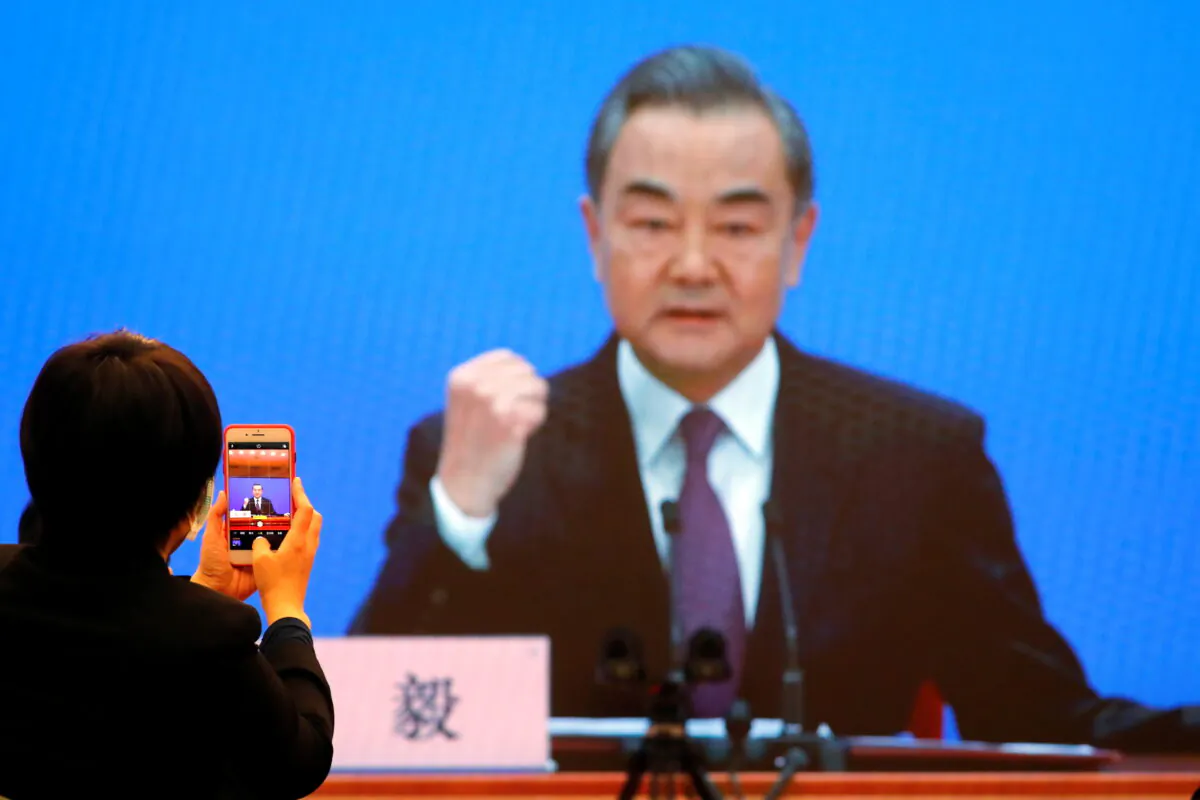 Chinese State Councillor and Foreign Minister Wang Yi is displayed on a screen as he attends via video link a news conference on the sidelines of the National People's Congress (NPC), in Beijing, China on March 7. (Reuters/Thomas Peter)