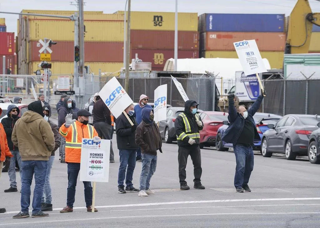 Striking dockworkers from the Port of Montreal walk the picket line during the first day of a strike in Montreal on April 26, 2021. Federal Labour Minister Filomena Tassi has tabled a bill to put an end to the strike involving 1,150 dockworkers at the Port of Montreal. (Paul Chiasson/The Canadian Press)