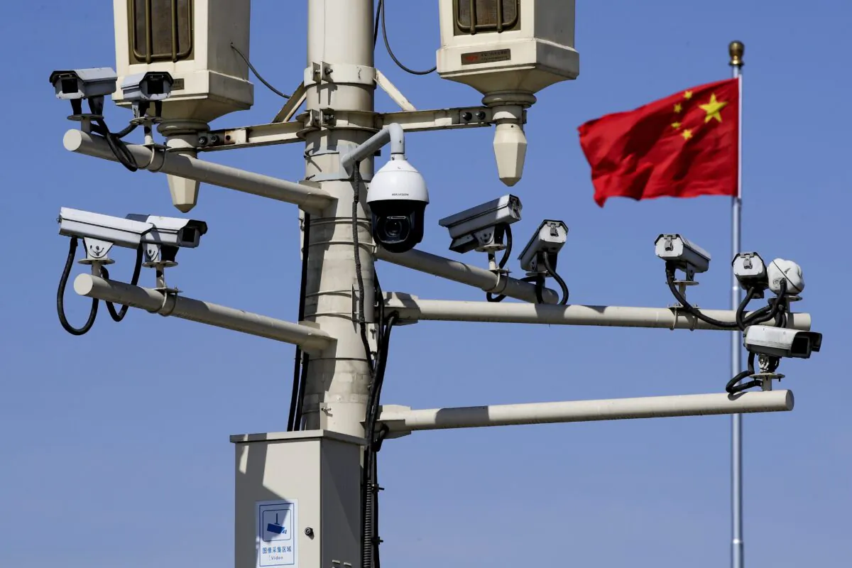 A Chinese national flag flutters near surveillance cameras mounted on a lamp post in Tiananmen Square in Beijing, China, on March 15, 2019. (Andy Wong/AP Photo)
