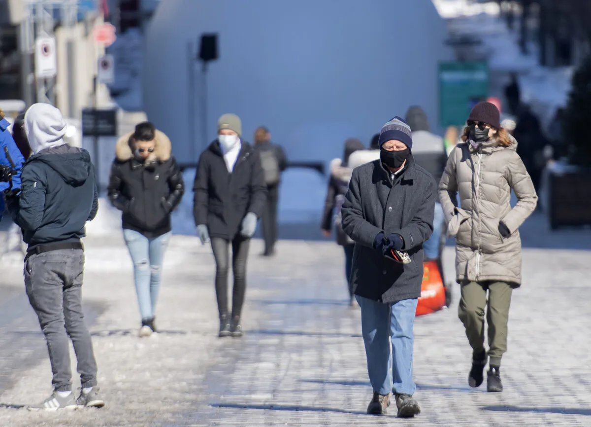 People walk along a street in Montreal on Feb. 21, 2021. (Graham Hughes/The Canadian Press)