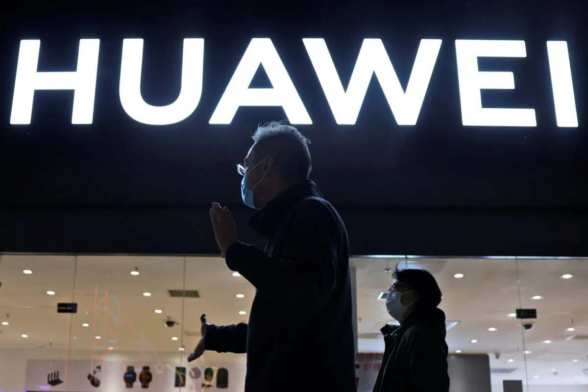 Residents pass by a Huawei electronics store in Beijing, on April 12, 2021. (Ng Han Guan/AP Photo)