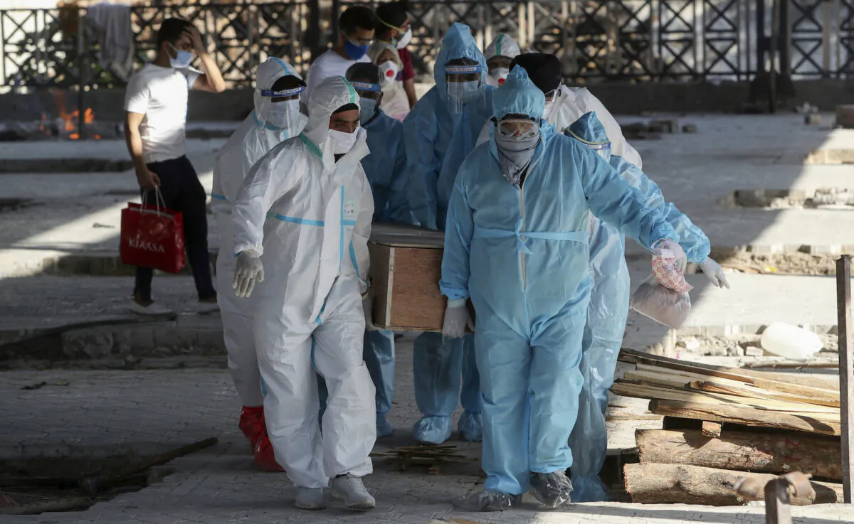 Health workers and relatives carry the body of a COVID-19 victim for cremation in Jammu, India, on April 26, 2021. (Channi Anand/AP Photo)