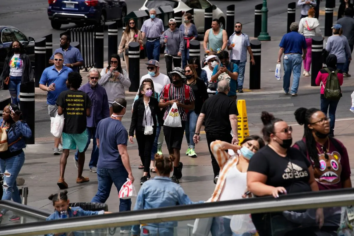 Masked and unmasked pedestrians walk along the Las Vegas Strip in Las Vegas, on April 27, 2021. (John Locher/AP Photo)