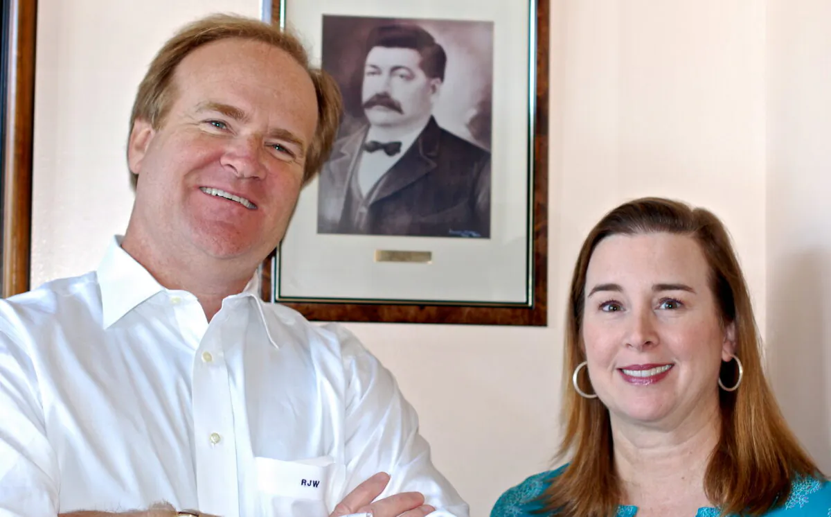 Robert J. Whann IV, known as Sandy, and Katherine Whann, fourth-generation members of the family, run the business today. Behind them is a framed photo of George Leidenheimer. (Photograph taken by the Southern Foodways Alliance)