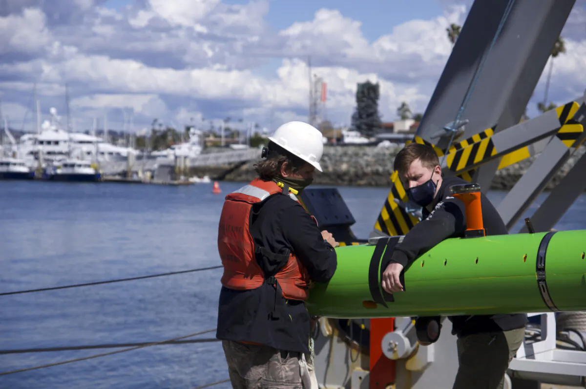 In this March 2021 image provided by Scripps Institution of Oceanography at UC San Diego, researchers aboard the research vessel Sally Ride recover an autonomous underwater vehicle after a search for discarded barrels near Santa Catalina Island, Calif. (Scripps Institution of Oceanography at UC San Diego via AP)