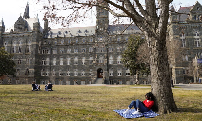 A student studies in the sunshine at Georgetown University in Washington, on March 9, 2021. (Kevin Lamarque/Reuters)