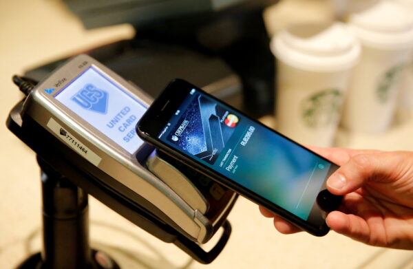 Man uses iPhone 7 smartphone to demonstrate mobile payment service Apple Pay at cafe in Moscow