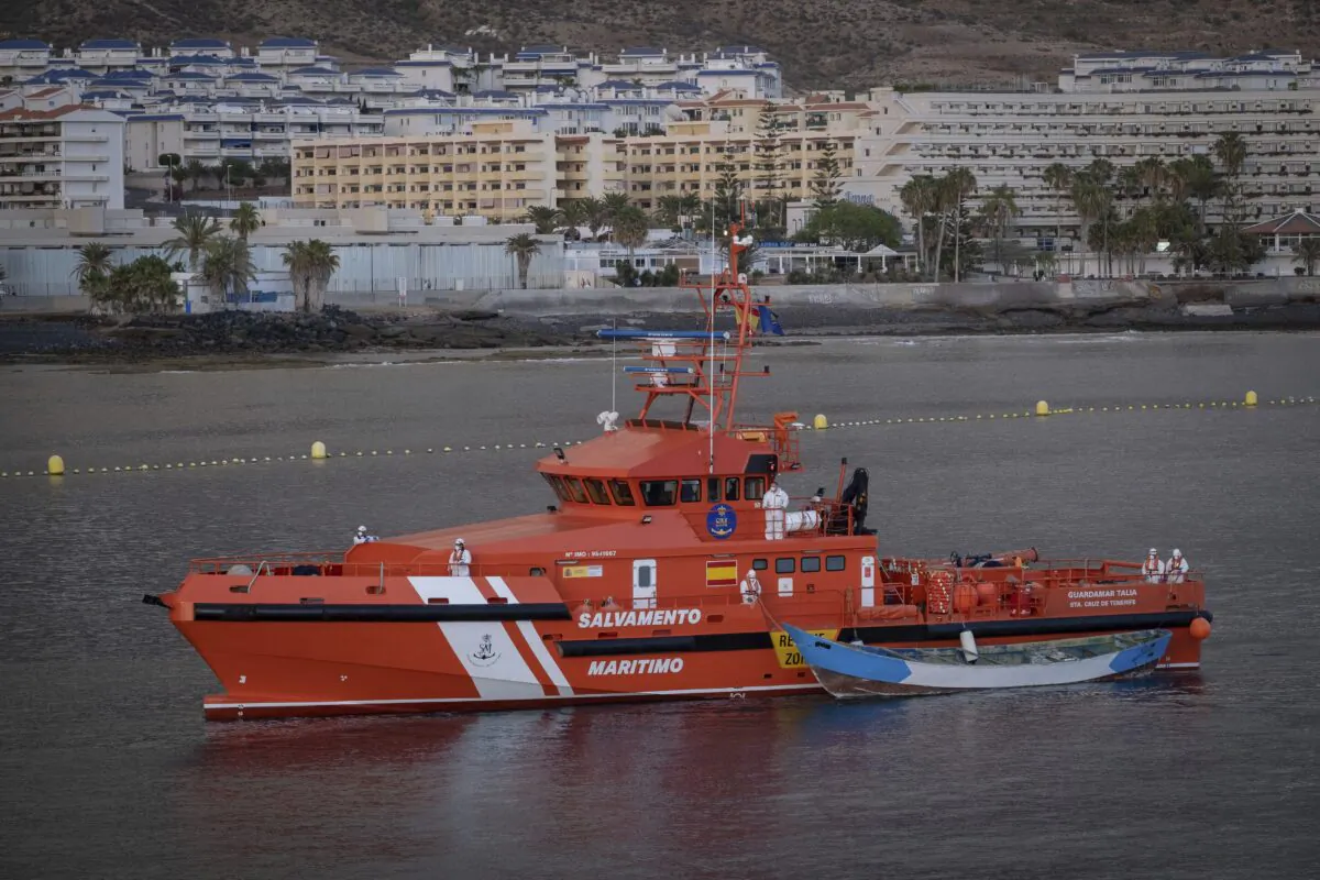 A wooden boat is towed by a Spanish Maritime Rescue Service ship as they arrive at the port of Los Cristianos in the south of Tenerife, in the Canary Islands, Spain, on April 28, 2021. (Andres Gutierrez/AP Photo)
