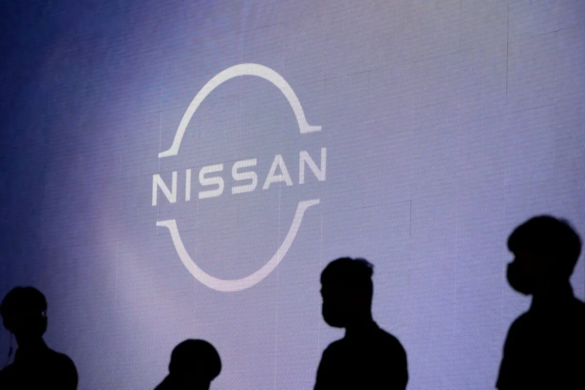 People stand near the Nissan logo during a media day for the Auto Shanghai show in Shanghai, China, on April 20, 2021. (Aly Song/Reuters)
