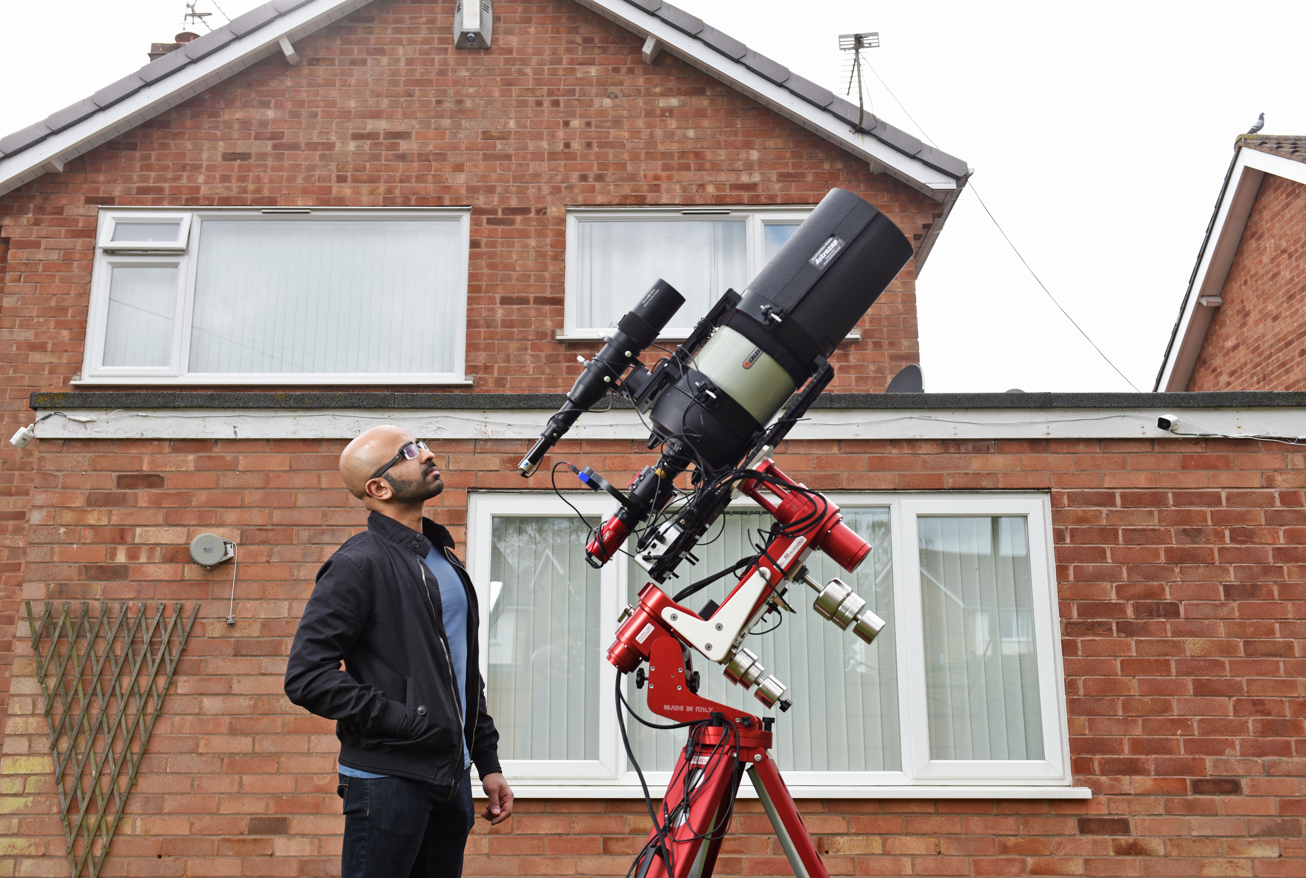 Syed Taha in his garden with his telescope
