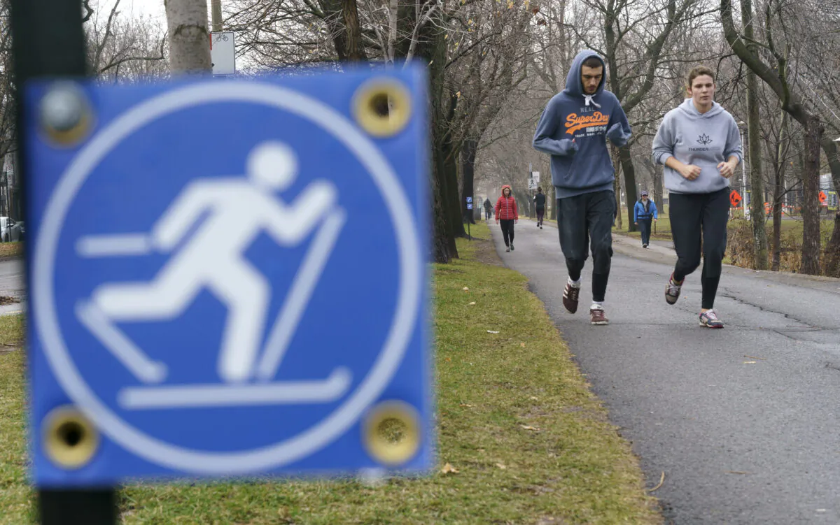 People jog in a park on a warm fall day in Montreal on Dec. 1, 2020. (The Canadian Press/Paul Chiasson)