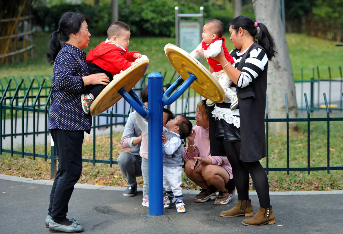 Women play with children at a park in Jinhua, Zhejiang province, China, on Nov. 5, 2018. (Stringer/Reuters)