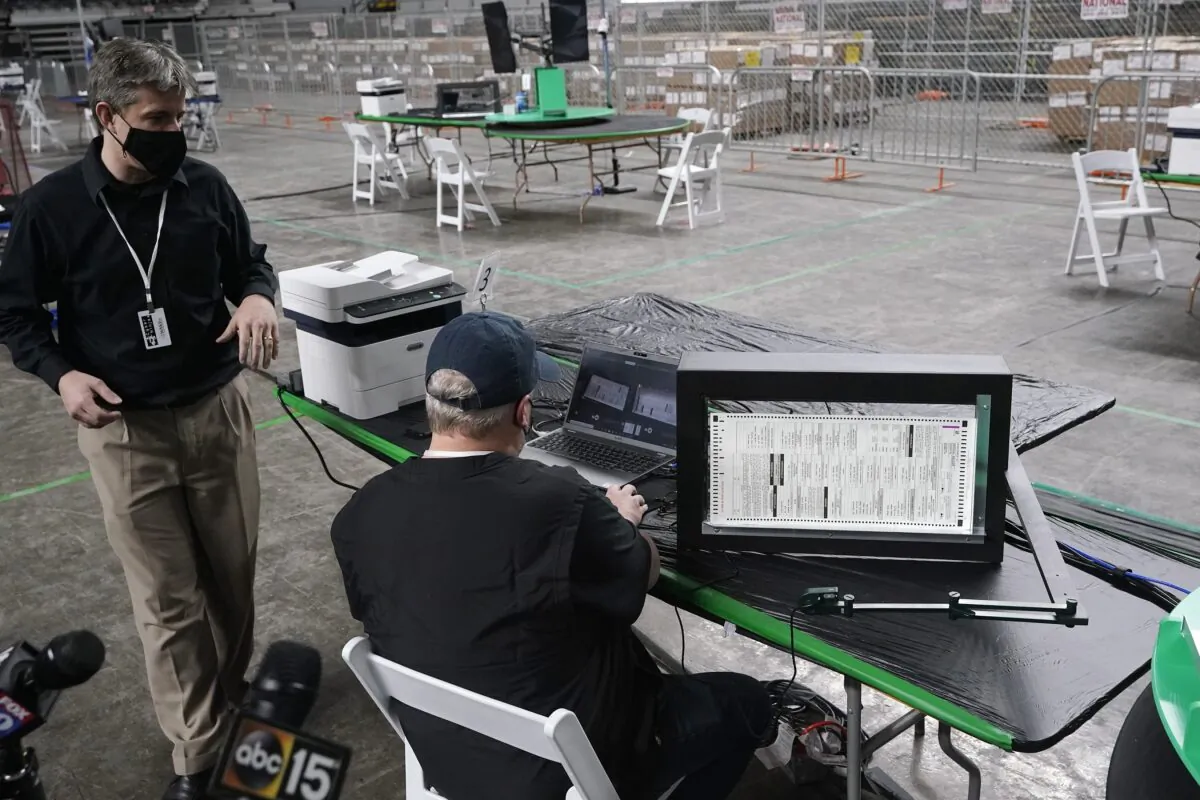 Cyber Ninjas owner Doug Logan, left, a Florida-based consultancy, talks about overseeing a 2020 election ballot audit ordered by the Arizona Senate, at the Arizona Veterans Memorial Coliseum in Phoenix, Ariz., on April 22, 2021. (Ross D. Franklin/AP Photo)
