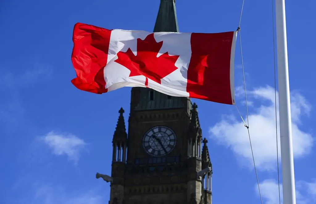 A Canadian flag is pictured with the Peace Tower on Parliament Hill in Ottawa on April 12, 2021. (The Canadian Press/Sean Kilpatrick)