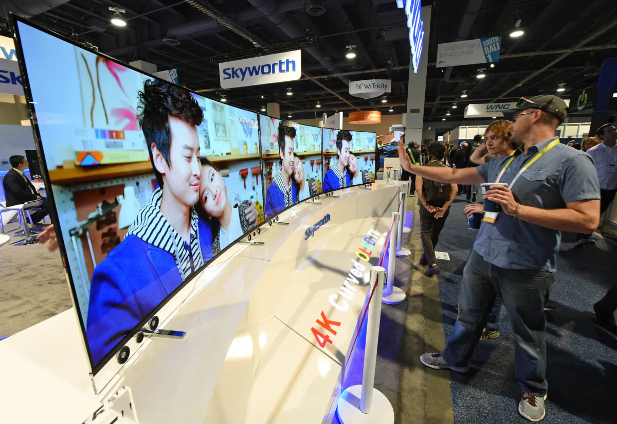 Attendees look at 65-inch Skyworth 4K curved OLED televisions on display at the 2015 International CES in Las Vegas, Nev., on Jan. 8, 2015.  (Ethan Miller/Getty Images)