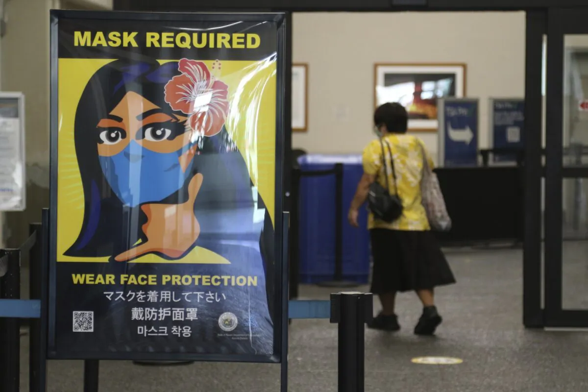 A woman walks into the international airport in Honolulu, amid a quarantine rule that effectively shut down the tourism industry in Hawaii, on Oct. 2, 2020. (Caleb Jones/ AP Photo)