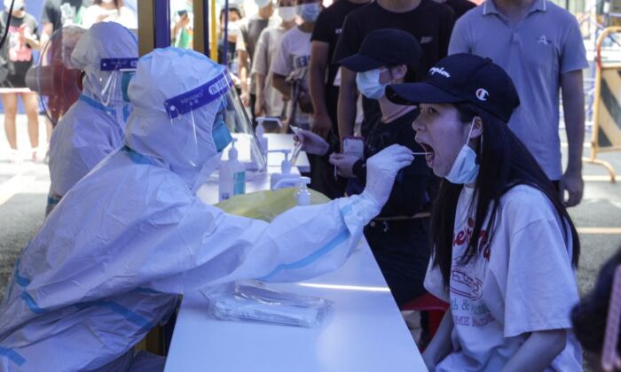 A woman (R) receives a nucleic acid test for the COVID-19 in Guangzhou, China, on May 30, 2021. (AFP via Getty Images)